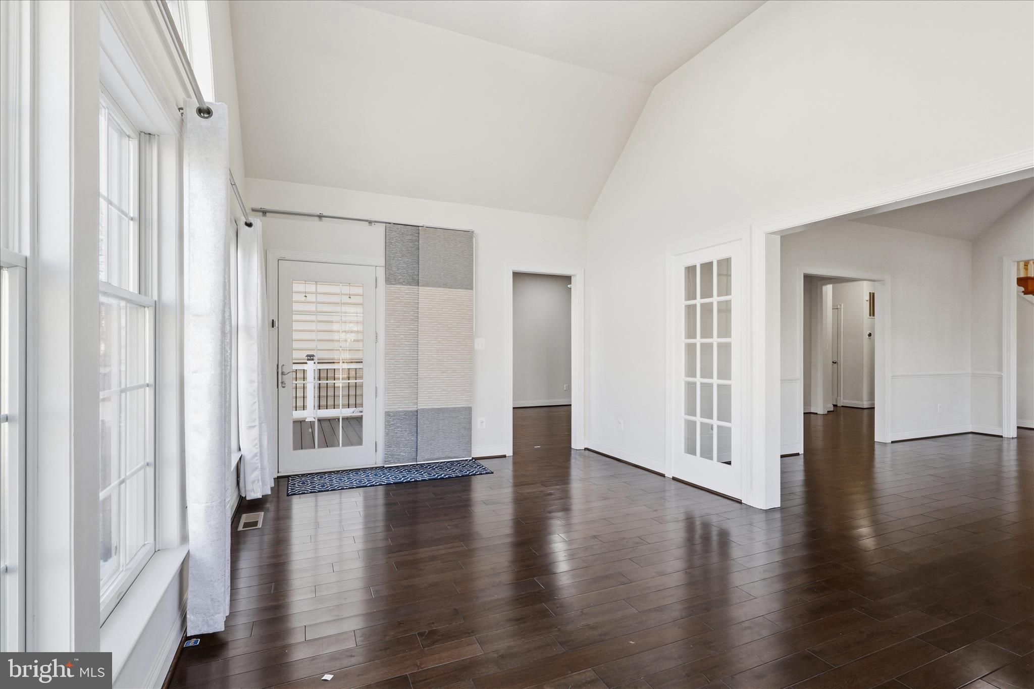 22908 North Brown Square Ashburn, VA 20148 - Photo 27 of 57 an empty room with wooden floor and windows with curtains