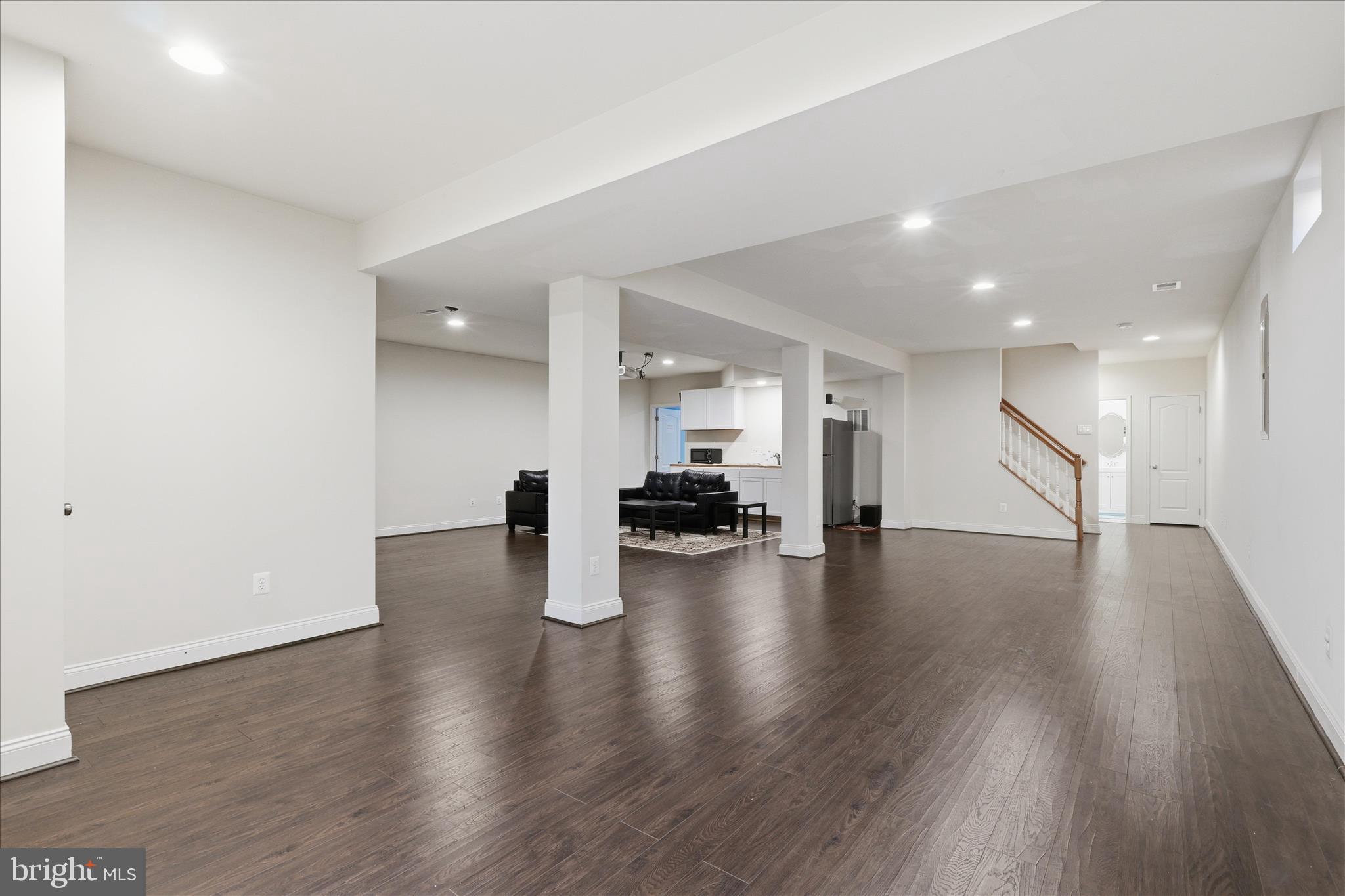 22908 North Brown Square Ashburn, VA 20148 - Photo 40 of 57 a view of an empty room with wooden floor and a kitchen
