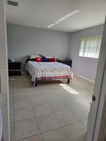 a large bedroom with a bed and a window in it