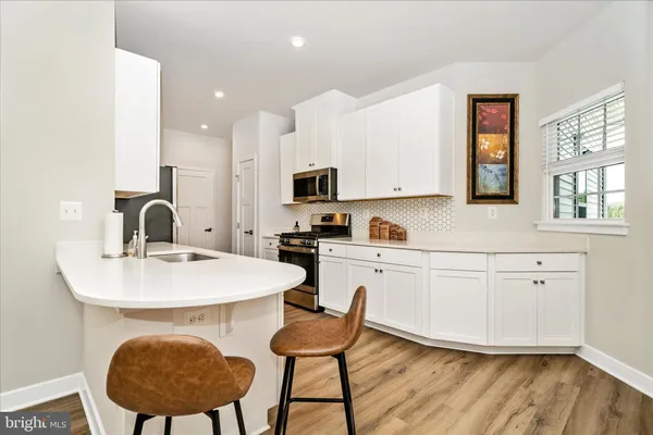 a kitchen with a white cabinets and chairs