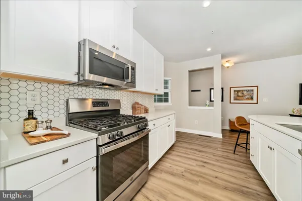 a kitchen with stainless steel appliances a sink stove top oven and cabinets