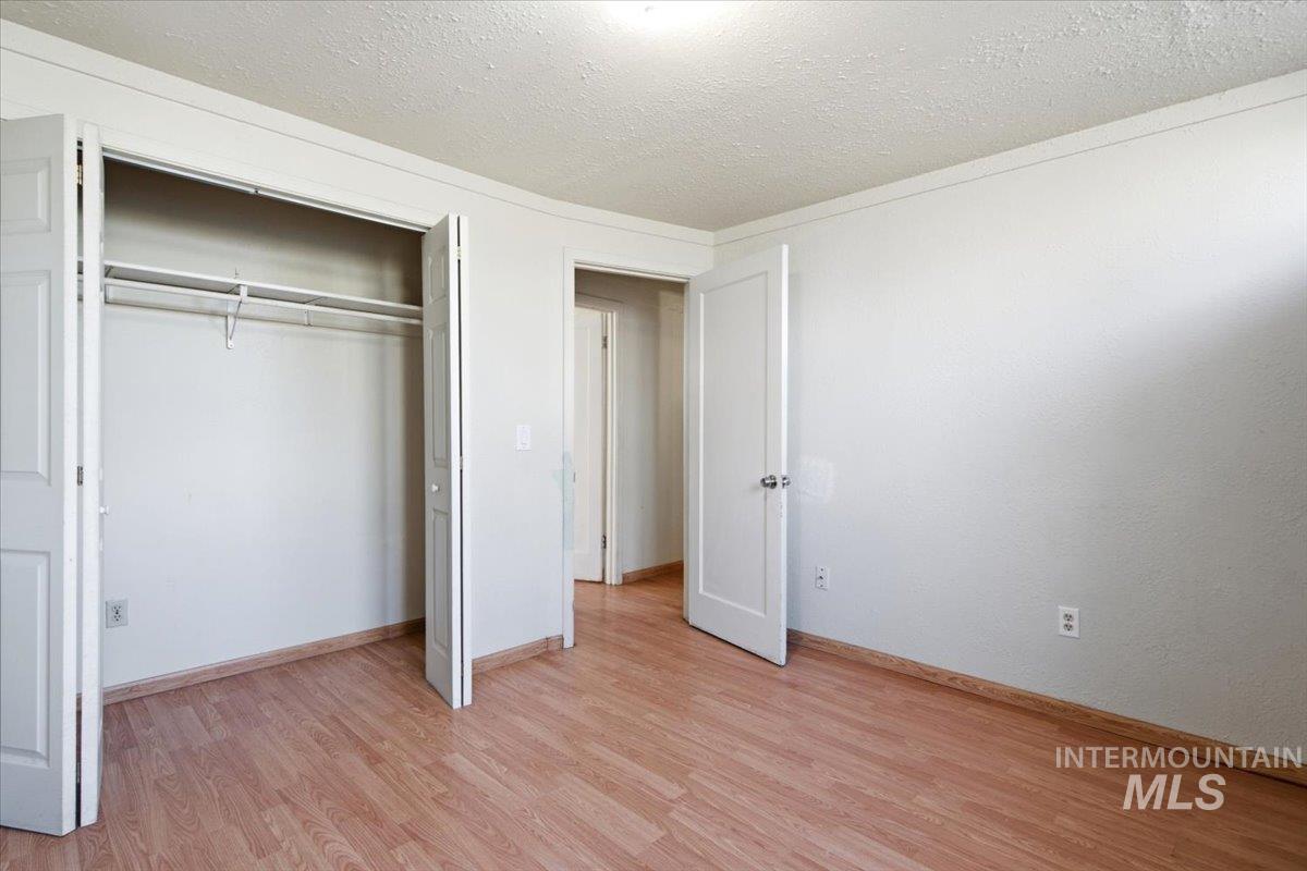 3929-3927 Homestead Road Homedale, ID 83628 - Photo 41 of 45 Wood-finish flooring with white trim and a closet featuring bi-fold doors