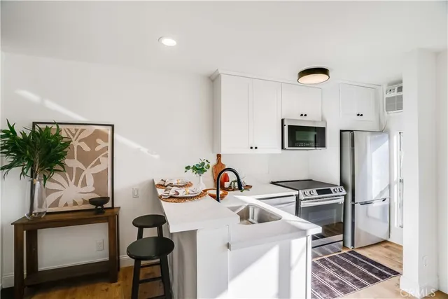 a kitchen with stainless steel appliances a sink a table and chairs