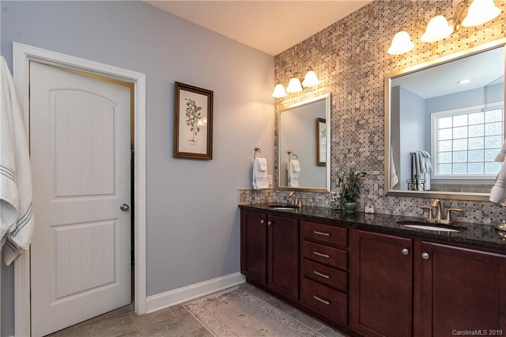 79026 Ridgehaven Road Lancaster, SC 29720 - Photo 17 of 30 a bathroom with double vanity sinks a toilet a mirror and window