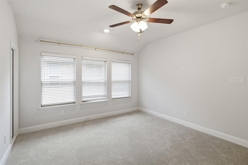 7416 Sequoia Rdg Road Little Elm, TX 76227 - Photo 30 of 37 Spacious room featuring vaulted ceilings, a ceiling fan with light fixture, three windows with blinds, light-colored carpeting, and white baseboards