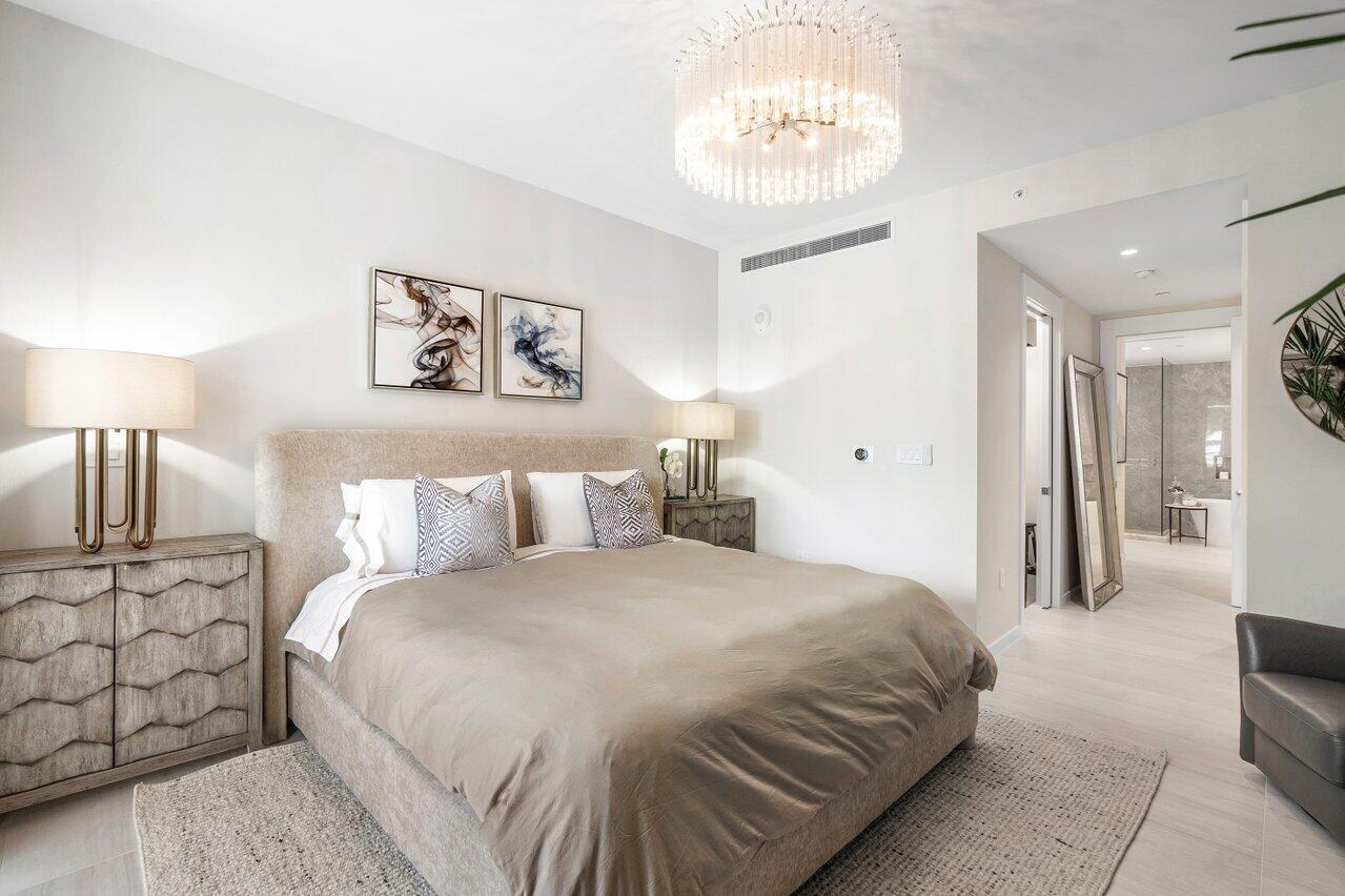 200 Southeast Mizner Boulevard, Unit 211 Boca Raton, FL 33432 - Photo 18 of 67 a bedroom with a bed and a lamp