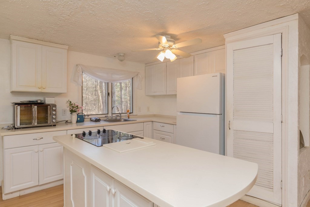 64 Hobbs Road Princeton, MA 01541 - Photo 3 of 22 a kitchen with a sink a stove a refrigerator and white cabinets