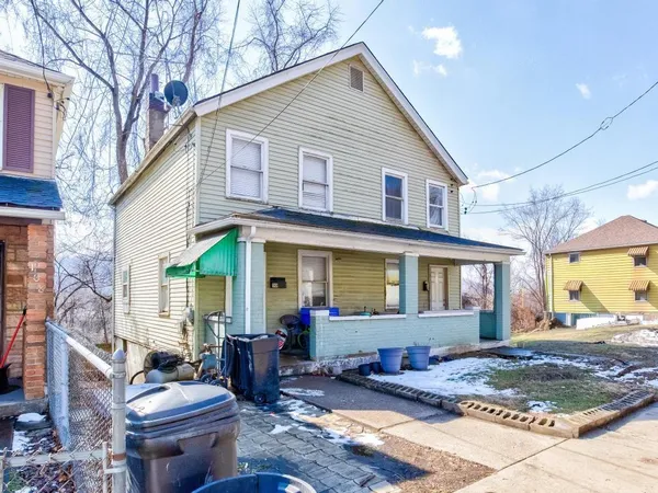 a front view of a house with outdoor seating and barbeque oven