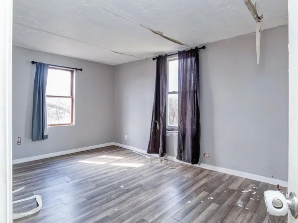 an empty room with wooden floor and door