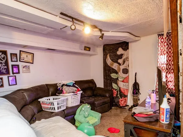 a living room with furniture and a baby crib