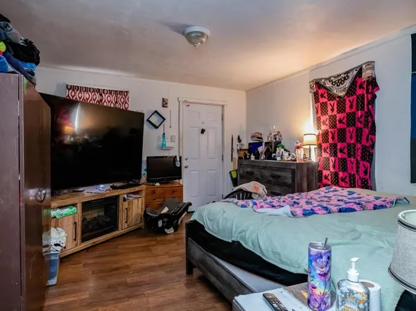 a bedroom with a bed and wooden floor