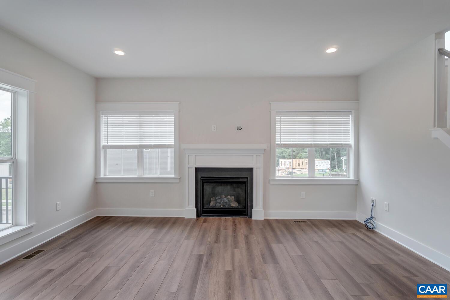 151 Agatha Ridge Lane Crozet, VA 22932 - Photo 20 of 52 an empty room with wooden floor fireplace and windows