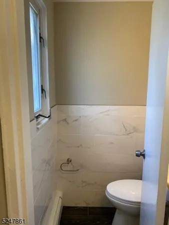 a bathroom with a granite countertop toilet and a sink