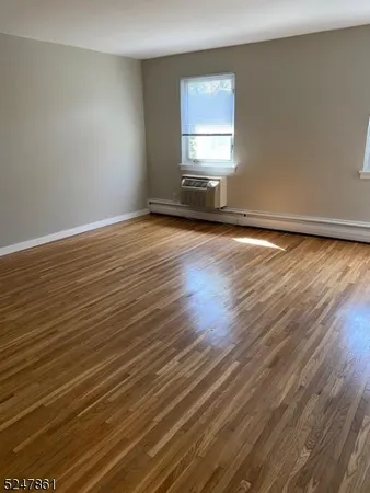 a view of a room with wooden floor and a window