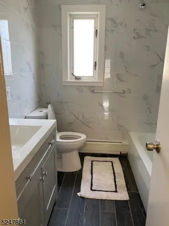 a bathroom with a sink toilet and window