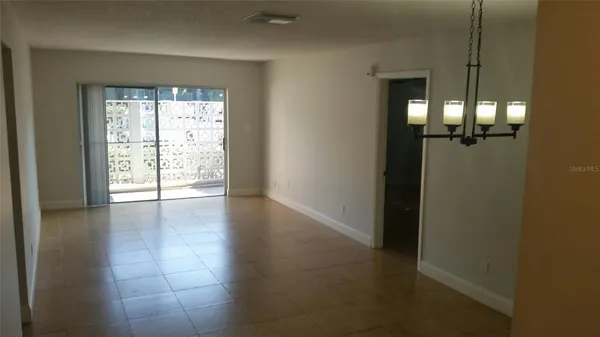 an empty room with windows and wooden floor