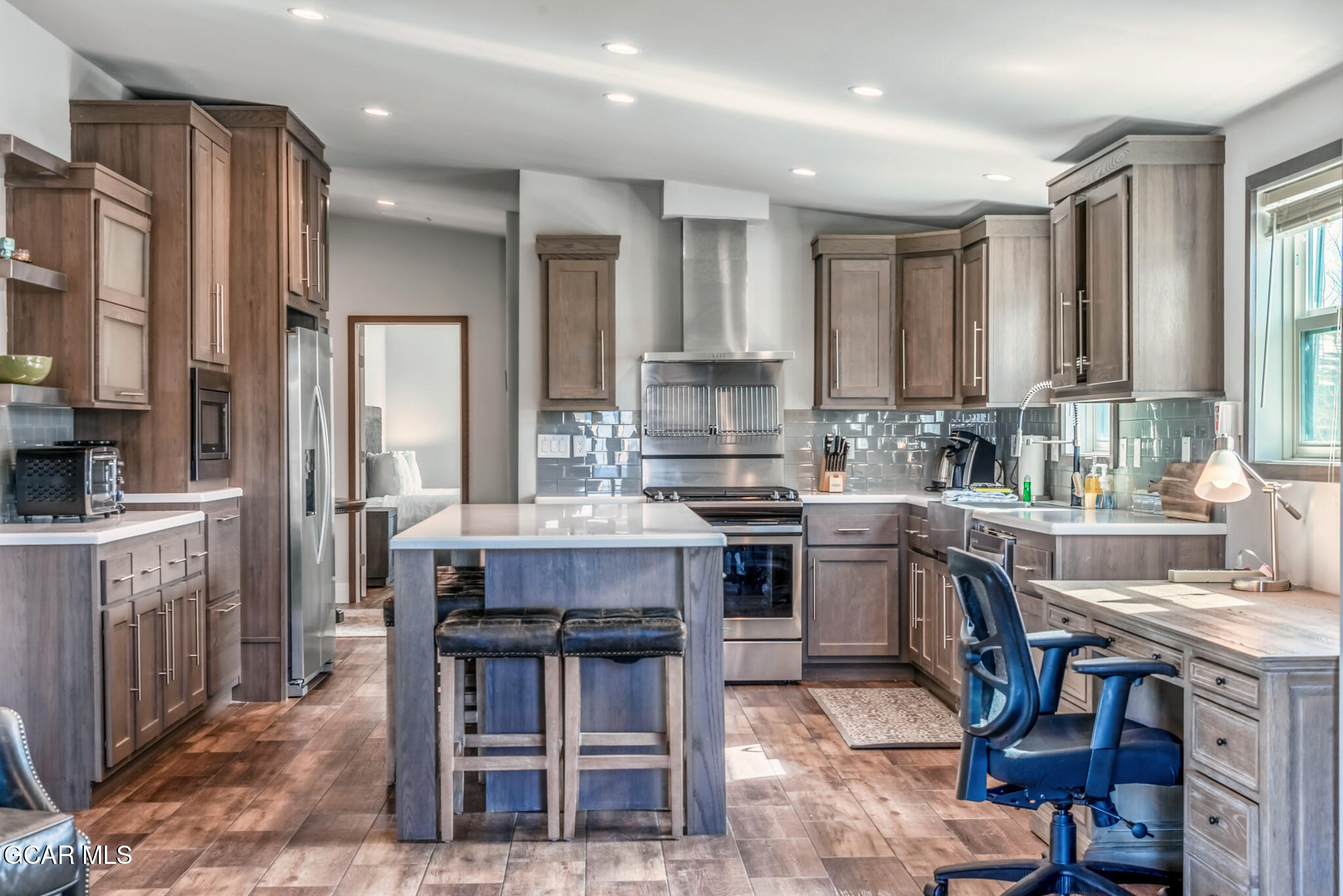 1051 Summit Trail Granby, CO 80446 - Photo 30 of 66 a kitchen with kitchen island granite countertop wooden cabinets and a refrigerator