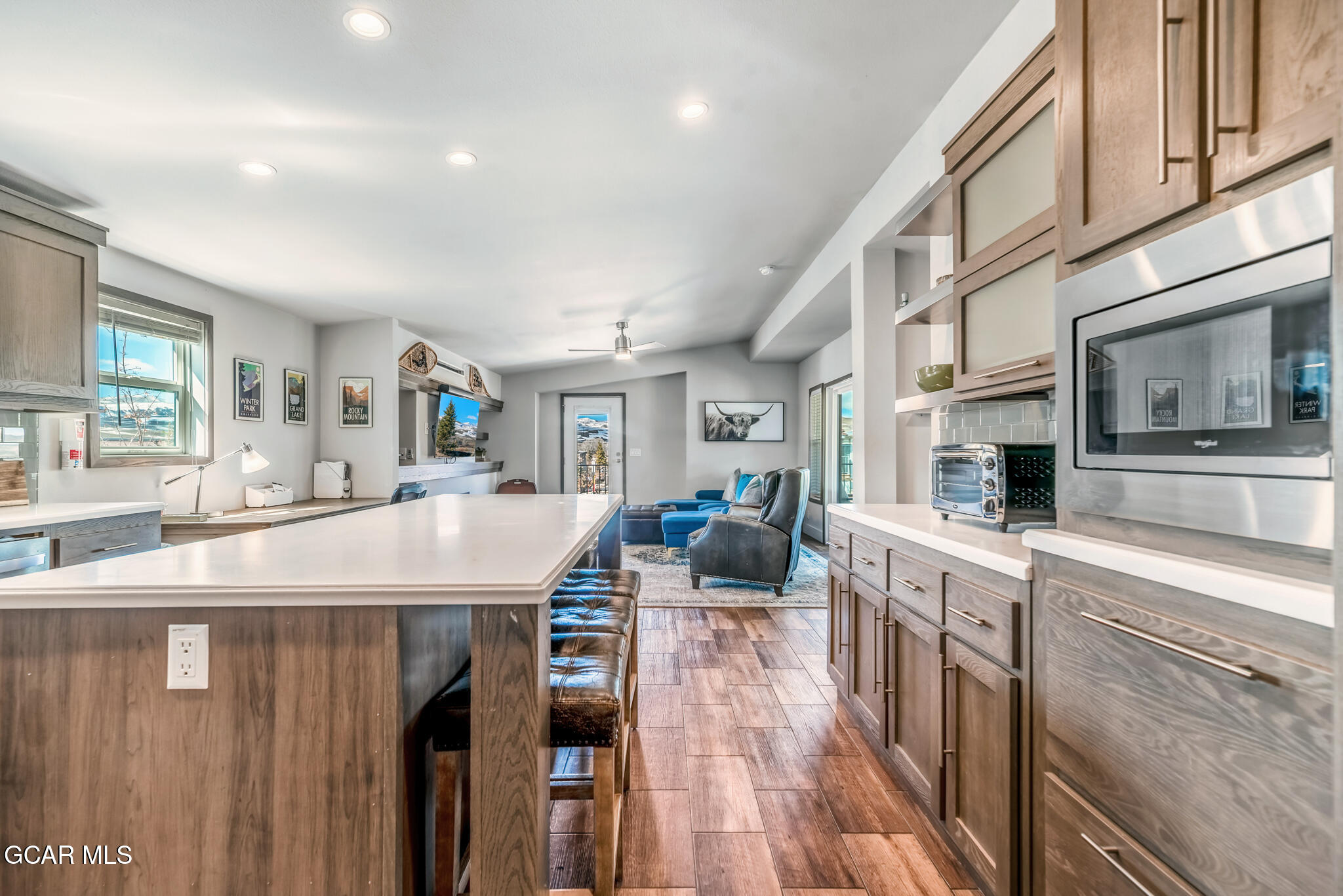 1051 Summit Trail Granby, CO 80446 - Photo 39 of 66 a living room with stainless steel appliances kitchen island granite countertop a refrigerator a stove top oven a dining table and chairs with wooden floor