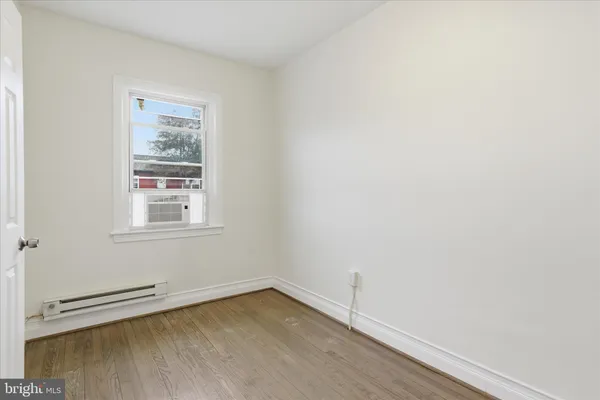 a view of a small space with wooden floor and a window