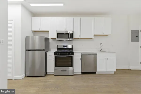 a kitchen with stainless steel appliances white cabinets and a refrigerator