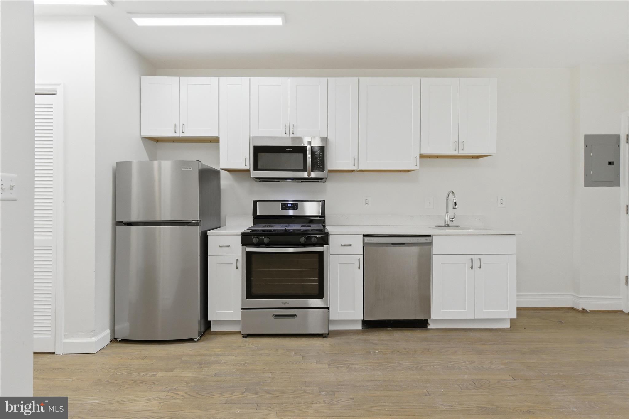 221 20th Street Northeast, Unit 3 Washington, DC 20002 - Photo 9 of 30 a kitchen with stainless steel appliances white cabinets and a refrigerator