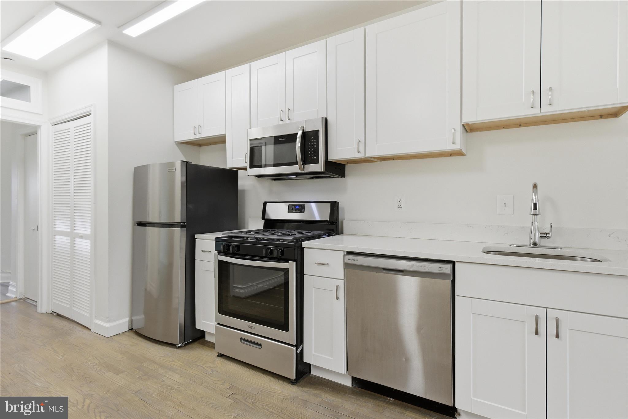221 20th Street Northeast, Unit 3 Washington, DC 20002 - Photo 10 of 30 a kitchen with stainless steel appliances granite countertop white cabinets a sink a stove a refrigerator and white cabinets