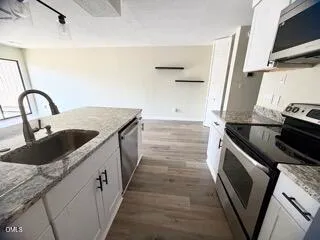 a kitchen with granite countertop a sink and a stove top oven