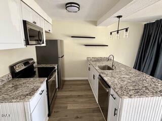 3071 Huntleigh Drive, Unit 3071 Raleigh, NC 27604 - Photo 15 of 25 a kitchen with stainless steel appliances granite countertop a sink stove and refrigerator