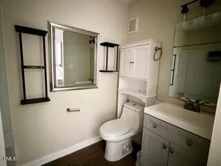 a bathroom with a toilet sink and a mirror