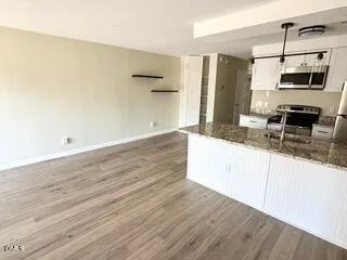 a kitchen with granite countertop a sink and a stove top oven