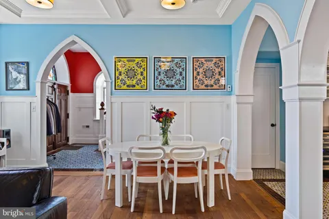 a kitchen with a chandelier a sink stainless steel appliances and cabinets
