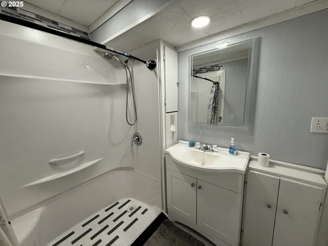 a bathroom with a sink a toilet and shower