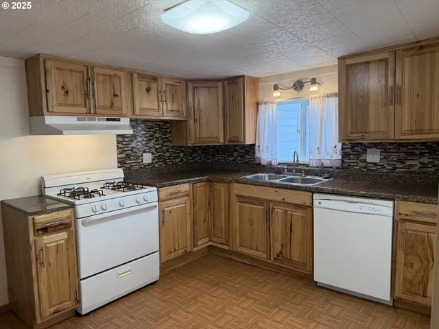a kitchen with granite countertop cabinets stainless steel appliances and a sink