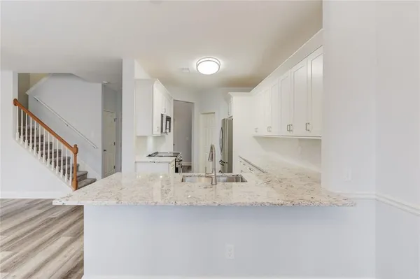 a kitchen with kitchen island granite countertop a sink and cabinets