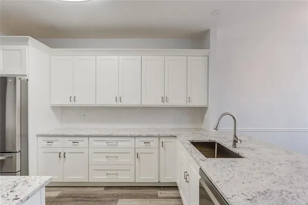 a kitchen with granite countertop white cabinets and sink