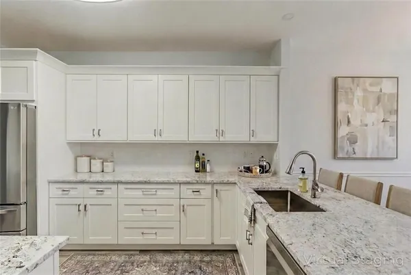 a kitchen with granite countertop a sink a stove and cabinets