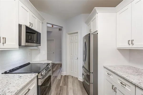 a kitchen with stainless steel appliances granite countertop a refrigerator stove and sink