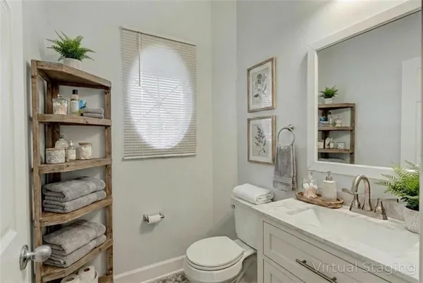 a bathroom with a granite countertop sink mirror vanity and toilet