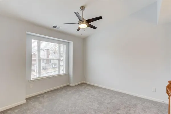 an empty room with a window and a fan