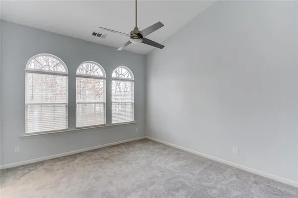 a spacious bedroom with a bed and large windows