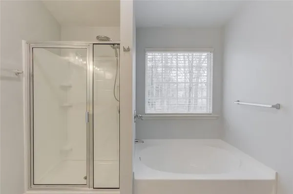 a white bath tub sitting next to a shower