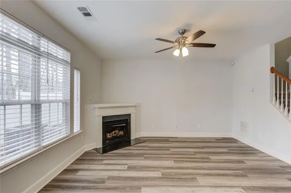 a view of empty room with fireplace and fan