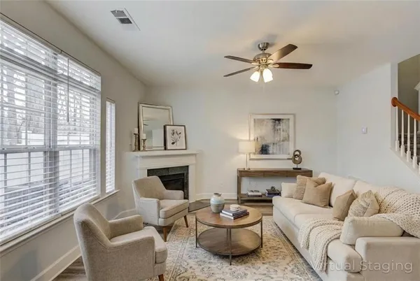 a living room with furniture a fireplace and a large window