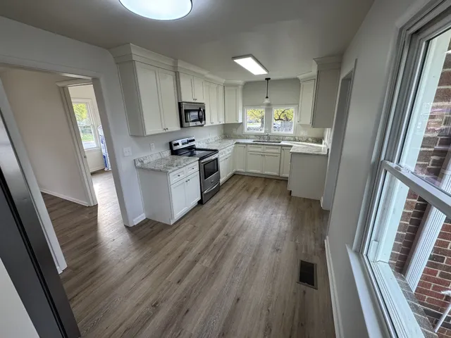 a kitchen with sink a microwave a stove and cabinets