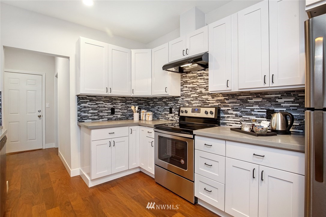 2317 Rucker Avenue Everett, WA 98201 - Photo 14 of 25 a kitchen with granite countertop white cabinets and white appliances