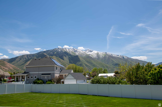 646 East 1400th Street North Mapleton, UT 84664 - Photo 78 of 78 Expansive backyard featuring a manicured lawn, white vinyl fencing, and a two-story residence with a covered porch