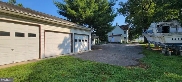 a view of backyard with barbeque grill and a large tree