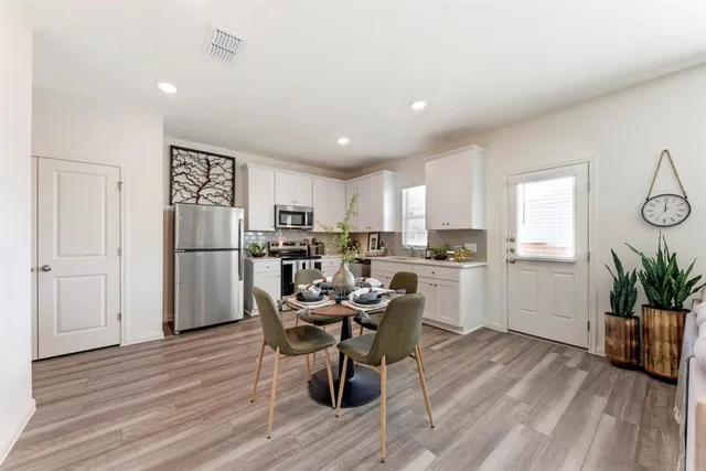 a kitchen with a refrigerator and a table chair