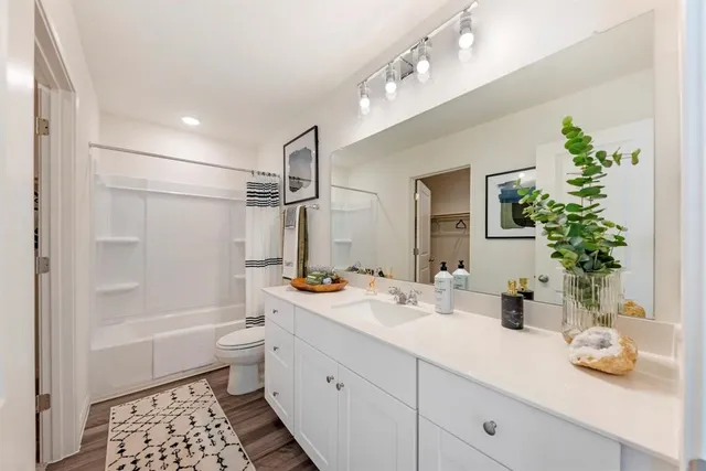 a bathroom with a granite countertop sink a toilet and shower