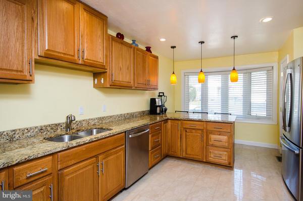 8011 Langbrook Road Springfield, VA 22152 - Photo 7 of 30 a kitchen with stainless steel appliances granite countertop a sink a stove and a refrigerator